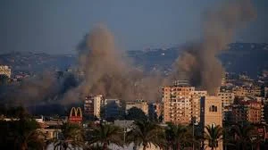 Smoke rises after Israeli airstrikes hit a highway near Beirut airport road in Lebanon during escalating regional tensions.