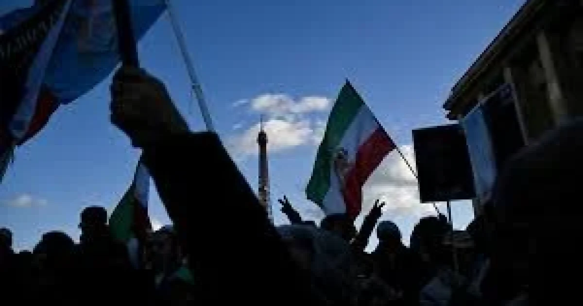 Protesters in Tehran holding banners and raising their fists amid heavy police presence during nationwide demonstrations in Iran, January 2026.